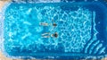 Active girls in swimming pool water aerial drone view from above, children swim, kids have fun on tropical family vacation Royalty Free Stock Photo