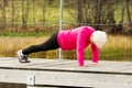 Active grandmum doing push-ups on fresh air. Royalty Free Stock Photo