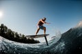 Active guy balancing on the wave with hydrofoil foilboard on background of blue sky Royalty Free Stock Photo