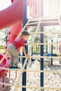 Active happy brave Caucasian boy child climbing staircase climber on playground schoolyard