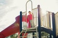 Active happy brave Caucasian boy child climbing staircase climber on playground schoolyard outdoors on summer sunny day. Seasonal