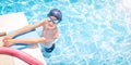 Active, happy child (boy) in cap, sport goggles ready to learns professional swimming with pool board, swim noodles. Royalty Free Stock Photo