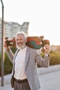 Active happy cool older business man skater holding skateboard in city. Royalty Free Stock Photo