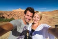 Active happy couple taking selfie on travel at Ait Benhaddou kasbah, Ouarzazate, Morocco.