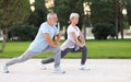 Active happy elderly family couple in sportswear working out together in city park on sunny morning Royalty Free Stock Photo