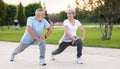 Active happy elderly family couple in sportswear working out together in city park on sunny morning Royalty Free Stock Photo