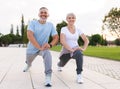 Active happy elderly family couple in sportswear working out together in city park on sunny morning Royalty Free Stock Photo