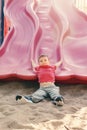 Active happy funny smiling Caucasian boy child sliding on playground schoolyard outdoor on summer sunny day Royalty Free Stock Photo