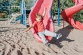 Active happy funny smiling Caucasian boy child sliding on playground schoolyard outdoors on summer sunny day. Kid having fun. Royalty Free Stock Photo