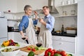 Active happy old mature couple enjoying dancing and cooking together at home. Royalty Free Stock Photo