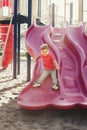 Active happy smiling Caucasian boy sliding on playground. Kid on schoolyard outdoors on summer sunny day. Child having fun outside Royalty Free Stock Photo