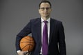 Active healthy businessman in formal clothes, tie holding basketball in hand