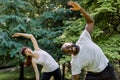 Active healthy couple, African guy and Caucasian girl, working out together outdoors, doing stretching exercises on the Royalty Free Stock Photo