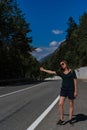 Active healthy girl tourist catches a car on the road