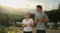 Active healthy mature woman jogging at the park with her personal trainer. Healthy lifestyle and fitness concept Royalty Free Stock Photo