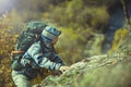 Active hiker with backpack climbs to the rock