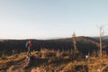 Active hiker enjoys the feeling of reaching the top of the mountain at sunrise. A hiker is enlightened by the morning sun and Royalty Free Stock Photo