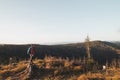 Active hiker enjoys the feeling of reaching the top of the mountain at sunrise. A hiker is enlightened by the morning sun and Royalty Free Stock Photo