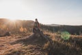 Active hiker sitting on a stump enjoys the feeling of reaching the top of the mountain at sunrise. A hiker is enlightened by the Royalty Free Stock Photo