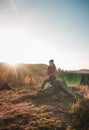 Active hiker sitting on a stump enjoys the feeling of reaching the top of the mountain at sunrise. A hiker is enlightened by the Royalty Free Stock Photo