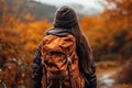 Active hiker woman on scenic autumn trail amidst vibrant fall foliage, embracing natures beauty