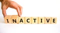Active or inactive symbol. Businessman turns wooden cubes and changes the word Inactive to Active. Beautiful white table white
