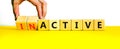 Active or inactive symbol. Businessman turns wooden cubes and changes the word Inactive to Active. Beautiful yellow table white