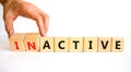 Active or inactive symbol. Businessman turns wooden cubes and changes the word Inactive to Active. Beautiful white table white