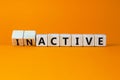 Active or inactive symbol. Turned wooden cubes and changed the concept word Inactive to Active. Beautiful orange table orange
