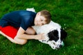 Active kid boy playing with family dog in garden. Laughing school child having fun with dog, with running and playing Royalty Free Stock Photo