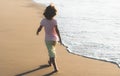 Active kid having fun on summer vacation. Child boy running on sand beach. Royalty Free Stock Photo