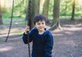 Active kid holding metal chains in playground, Child enjoying outdoors activity in a climbing rope chains in adventure park on Royalty Free Stock Photo