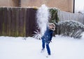 Active Kid throwing snowball on the road, Happy boy playing snow fight outdoor in the winter. Funny child throwing snow at camera Royalty Free Stock Photo