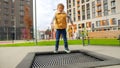 Active laughing boy jumping up high on the trampoline and having fun. Active child, sports and development, kids playing outdoors Royalty Free Stock Photo