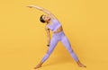 Active lifestyle. FIt black woman stretching her muscles before workout, exrcising indoors over yellow studio background Royalty Free Stock Photo