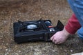 Active lifestyle. A man`s hand turns on a portable gas stove. An alternative source for cooking at home during a power outage