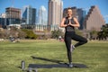 Active lifestyle portrait of smiling happy and healthy fit woman in yoga tree pose in Austin city park Royalty Free Stock Photo