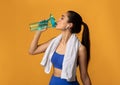 Sporty young woman drinking water from bottle at studio Royalty Free Stock Photo