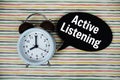 Active Listening text on speech bubble with alarm clock on colorful stripes background Royalty Free Stock Photo