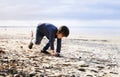 Active little boy playing with toys tank on the beach sand in the hot sunny day, 4-5 year old kid having fun with toy soldiers on