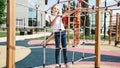 Active little child playing on rock climbing and jumping on school yard playground. Children play and climb outdoors on a sunny Royalty Free Stock Photo