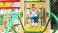 Active little child playing on rock climbing and jumping on school yard playground. Children play and climb outdoors on a sunny Royalty Free Stock Photo