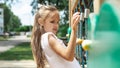 Active little child playing on rock climbing and jumping on school yard playground. Children play and climb outdoors on a sunny Royalty Free Stock Photo