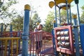 Active little girl running in the outdoor playground in the park. Happy child girl having fun on children playground. Play is Royalty Free Stock Photo