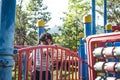 Active little girl running in the outdoor playground in the park. Happy child girl having fun on children playground. Play is Royalty Free Stock Photo