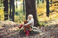 Active little girl with teddy bear in autumn forest. Active rest and activity on fresh air in woods.