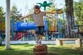 Active little girl walking on balance beam in the outdoor playground in the park. Happy child girl having fun in children Royalty Free Stock Photo