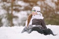 Active little healthy sport kid girl in ski suit and goggles sitting in snow at mountain winter resort with copy space during