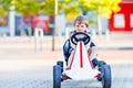 Active little kid boy driving pedal race car in summer garden, outdoors. child racing with fast speed and having fun Royalty Free Stock Photo