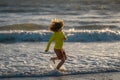 Active little kid running along sea beach during leisure sport activity. Sporty kid running in nature. Child run at Royalty Free Stock Photo
